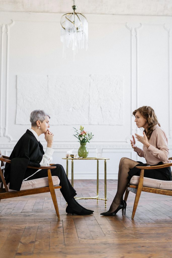 pexels-photo-4098368-4098368 Two women engaged in a counseling session in a bright, modern loft setting.